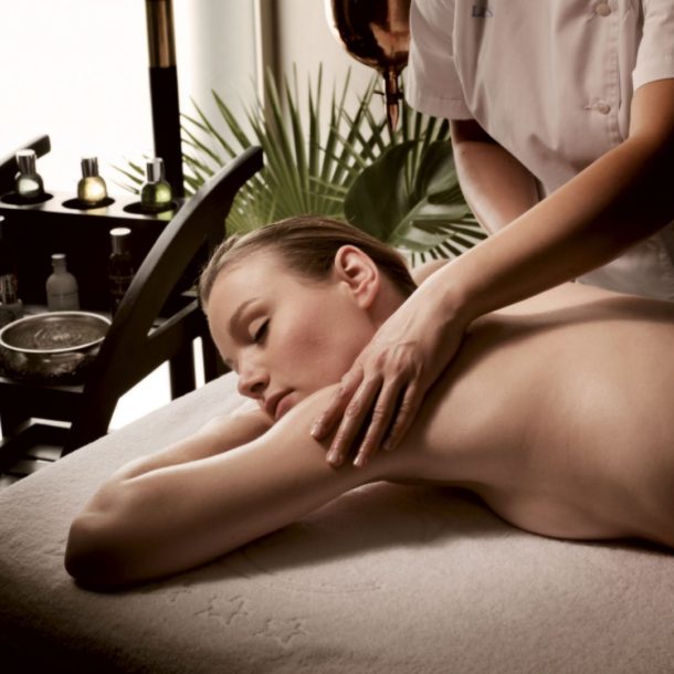 Woman receiving a back and shoulders massage on a spa bed.
