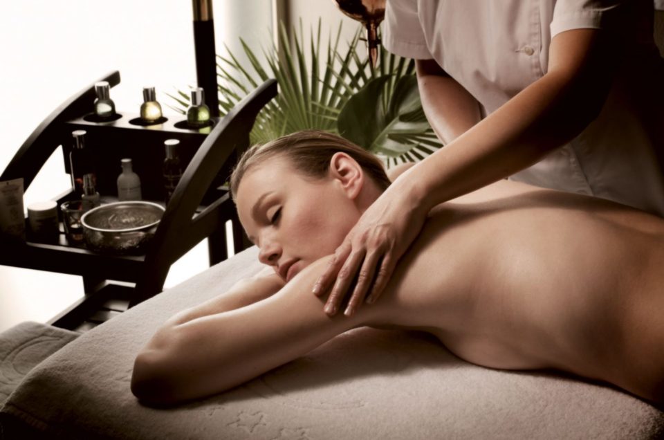 Woman receiving a back and shoulders massage on a spa bed.