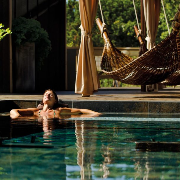 Woman relaxing in a pool at a resort.