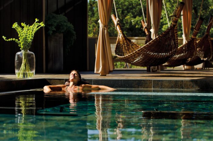 Woman relaxing in a pool at a resort.