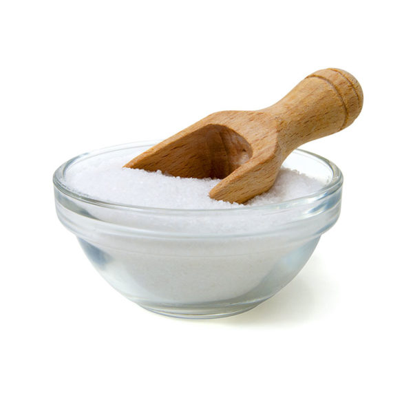Coarse salt in glass bown with wooden scoop.